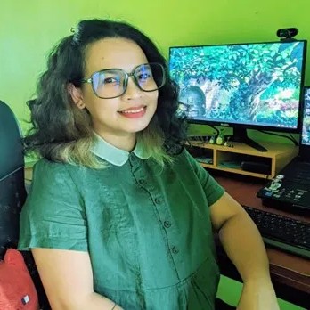 Portrait of Angelica Arra Fernandez wearing glasses and a green shirt